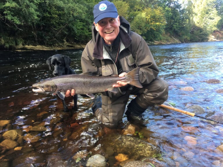 A man holding a fish in a river.