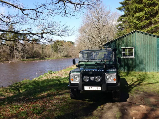 A green land rover parked in front of a shed, featured in Speycaster News.