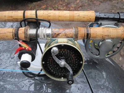 A fishing rod and reel sitting on top of a car.