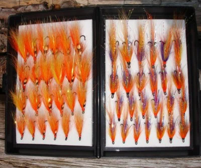 A set of orange and purple fly flies in a black case.