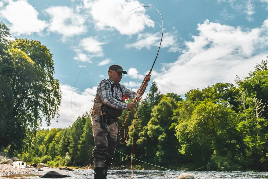 A man holding a fish in a river.